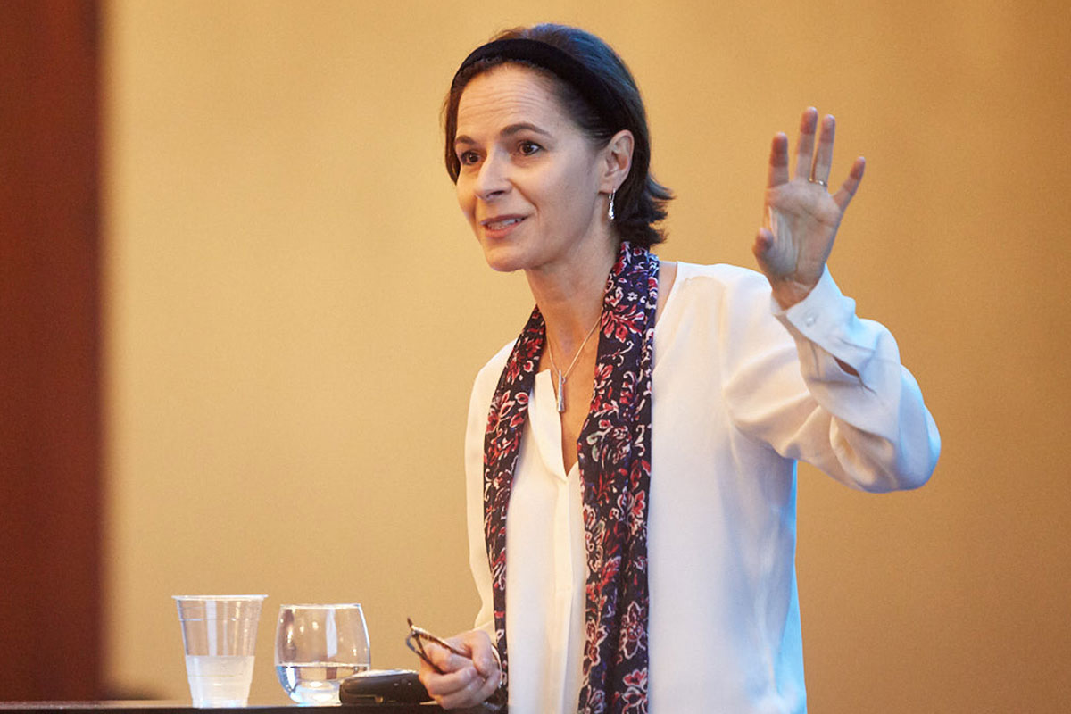 Yasmine Belkaid speaking with her hand raised.