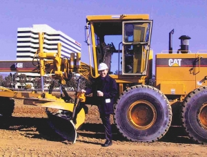 Kenneth Rainin standing in front of a tractor with a shovel, breaking ground on the Oakland location of Rainin Instruments.