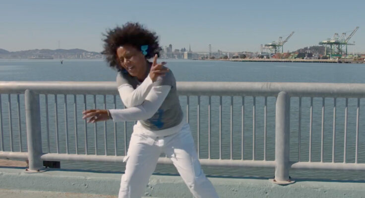 Amara Tabor-Smith mid-movement in front of the Oakland estuary.