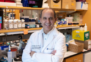 Dr. Scott Snapper in a white lab coat with his arms crossed, proudly smiling at camera.