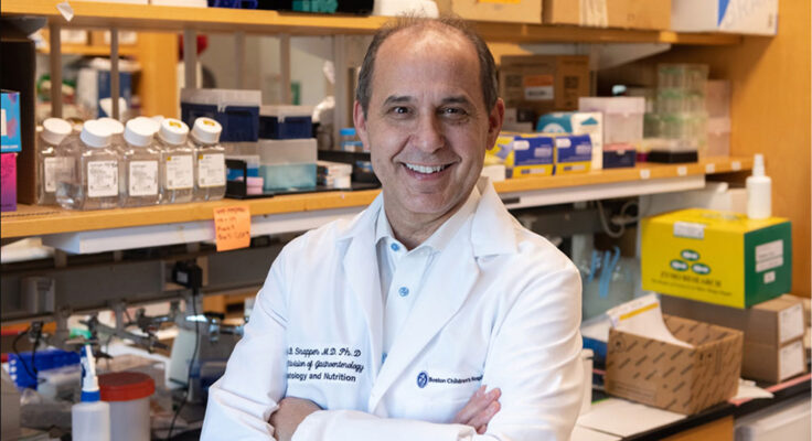 Dr. Scott Snapper in a white lab coat with his arms crossed, proudly smiling at camera.