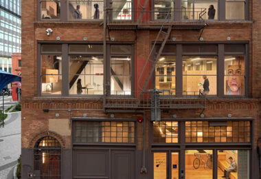 A multistory building in San Francisco with windows lit from within showcasing people moving about.