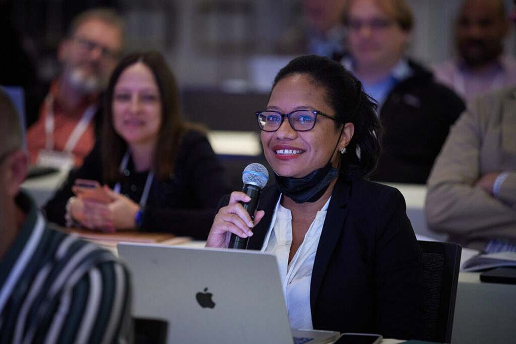 An audience member holding a microphone to ask a Symposium speaker a question.