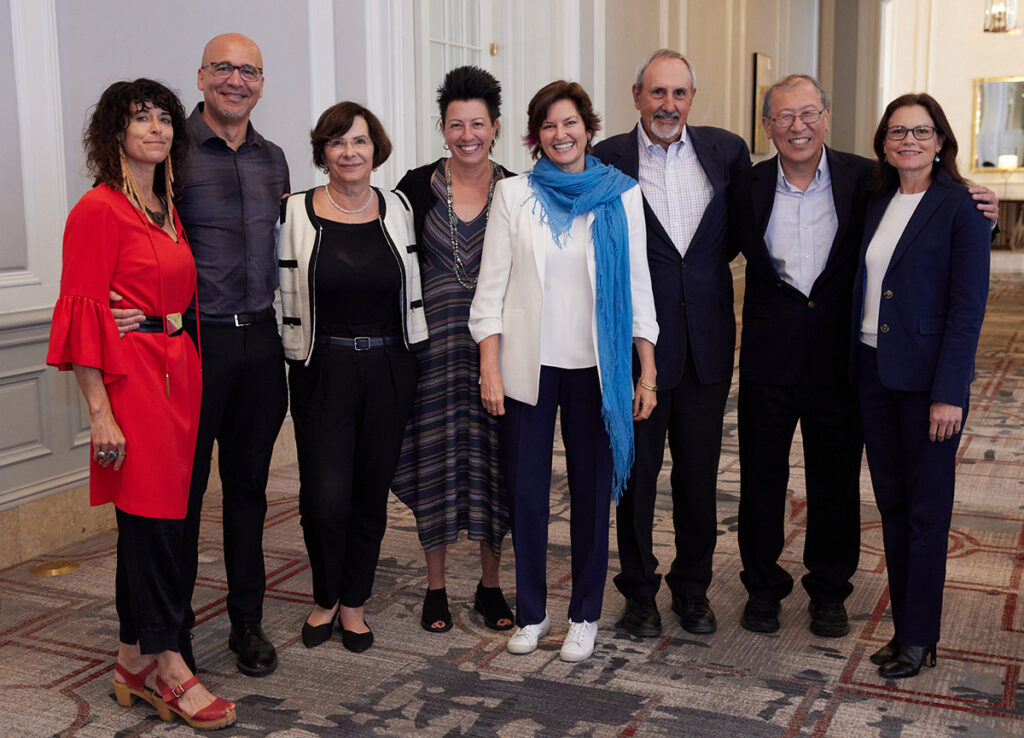 A group of women and men standing together and smiling