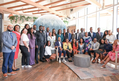 A group of 35 people pose smiling for the camera