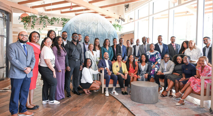 A group of 35 people pose smiling for the camera