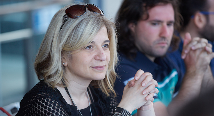 Dr. Karina Mariño sitting at a table with her hands folded in front of her.