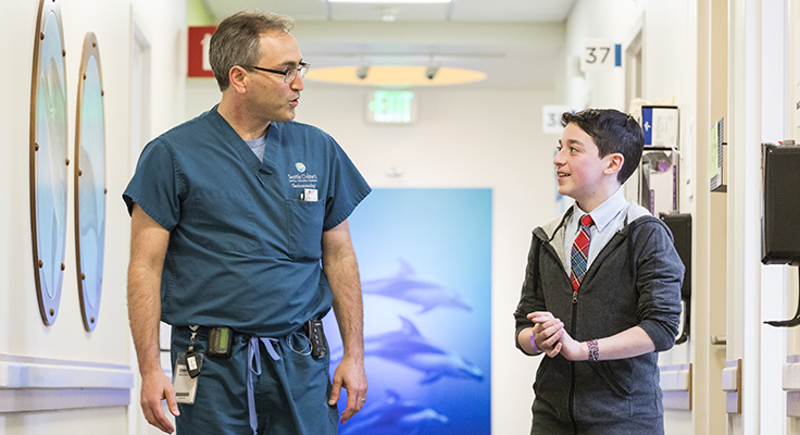 Dr. David Suskind walking down the hallway of a medical building with a young patient