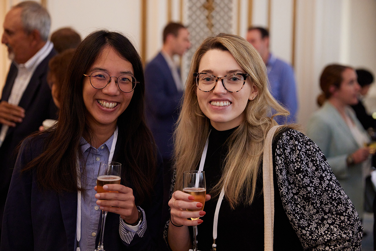 Two people holding champagne glasses, smiling at the camera.
