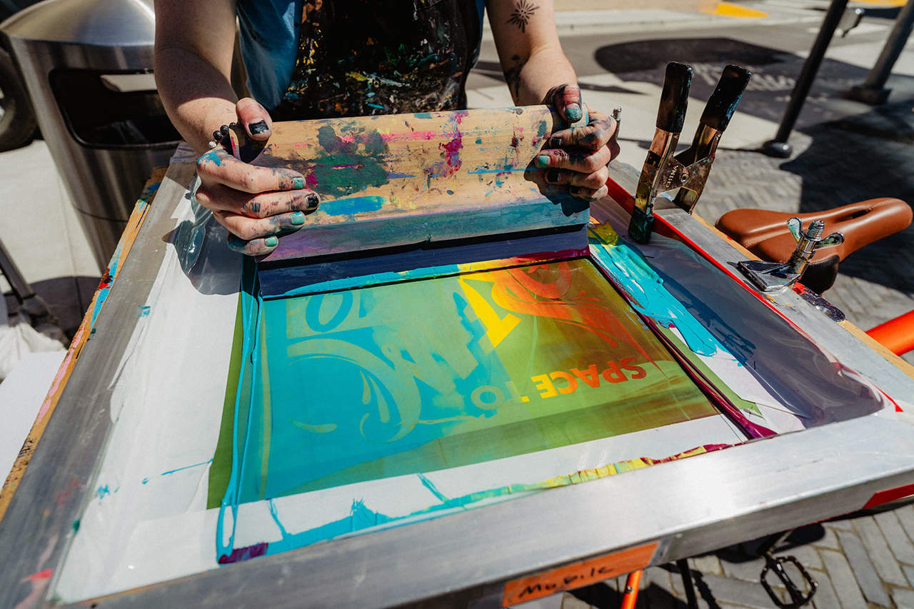 Hands shown making a colorful print.