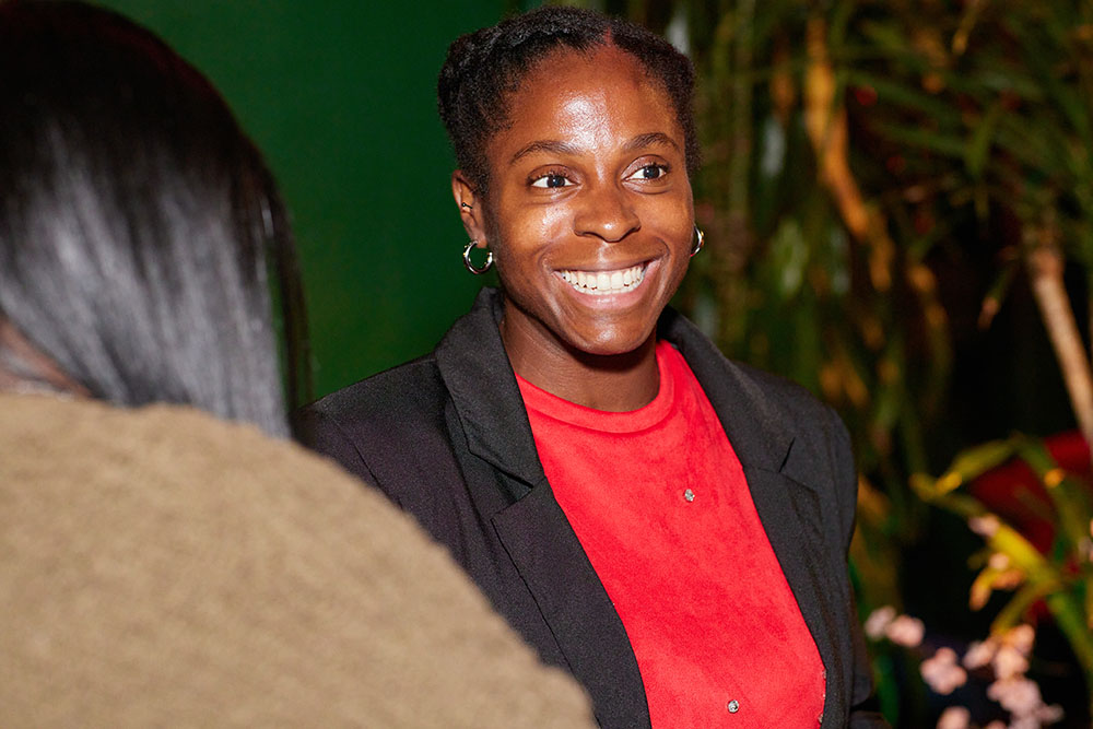 A person with a toothy grin looks at someone not in the photo.