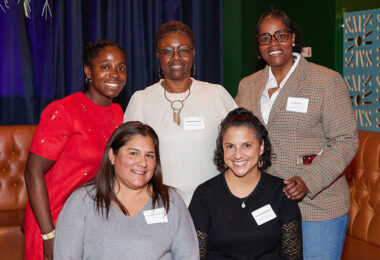 Five people are posing and smiling for the camera.