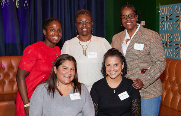 Five people are posing and smiling for the camera.