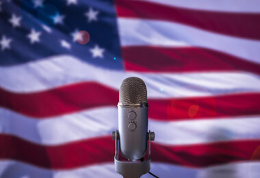 A microphone pictured in front of the American flag.