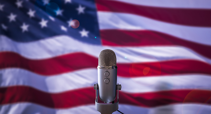 A microphone pictured in front of the American flag.