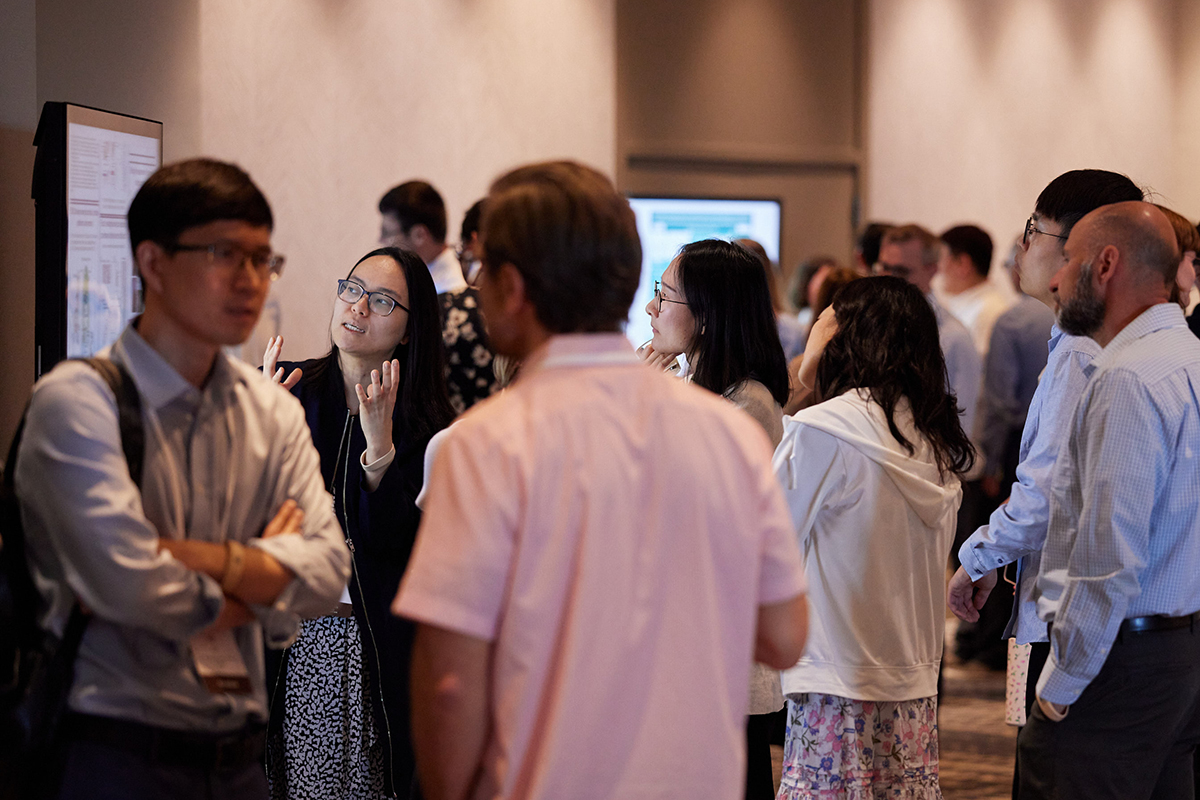Many people connecting and exploring research during a poster session.