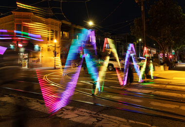 Trails of colorful light along a crosswalk.