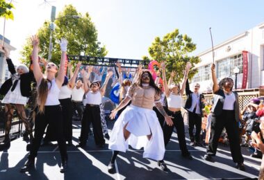 12 performers on an outdoor stage