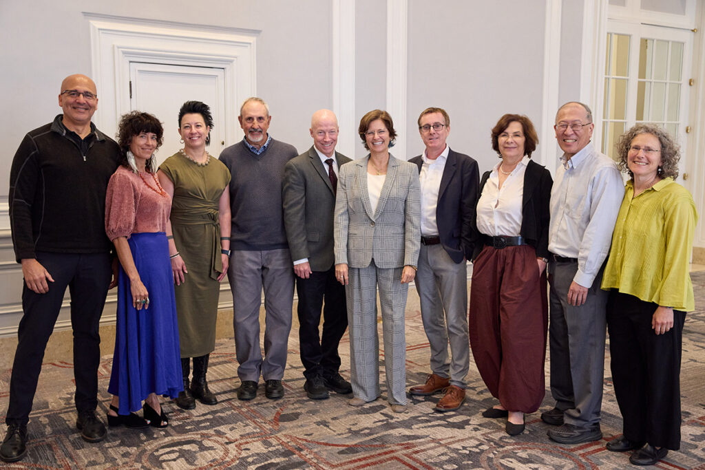 A large group photo of ten people standing together, smiling at the camera.