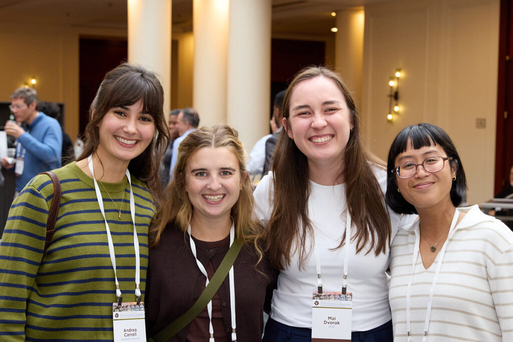 Four people standing together, smiling at the camera.