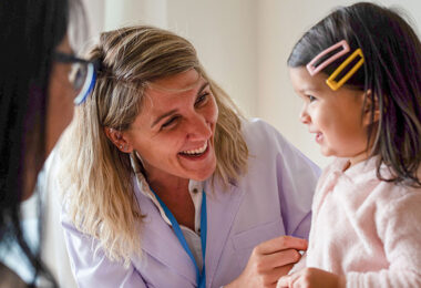 A doctor with a young patient in a health care setting.