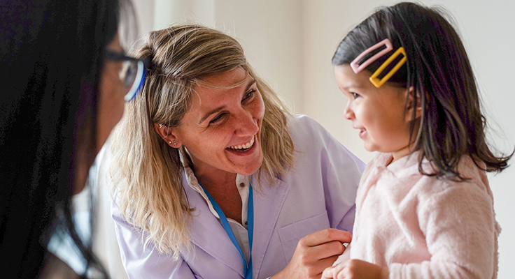 A doctor with a young patient in a health care setting.