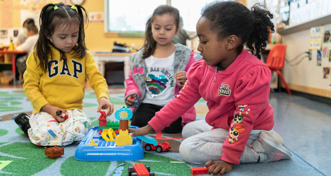 2024_TurningPoints_EDUC_OaklandStartingSmartStrong A group of three children are playing together with colorful large legos.